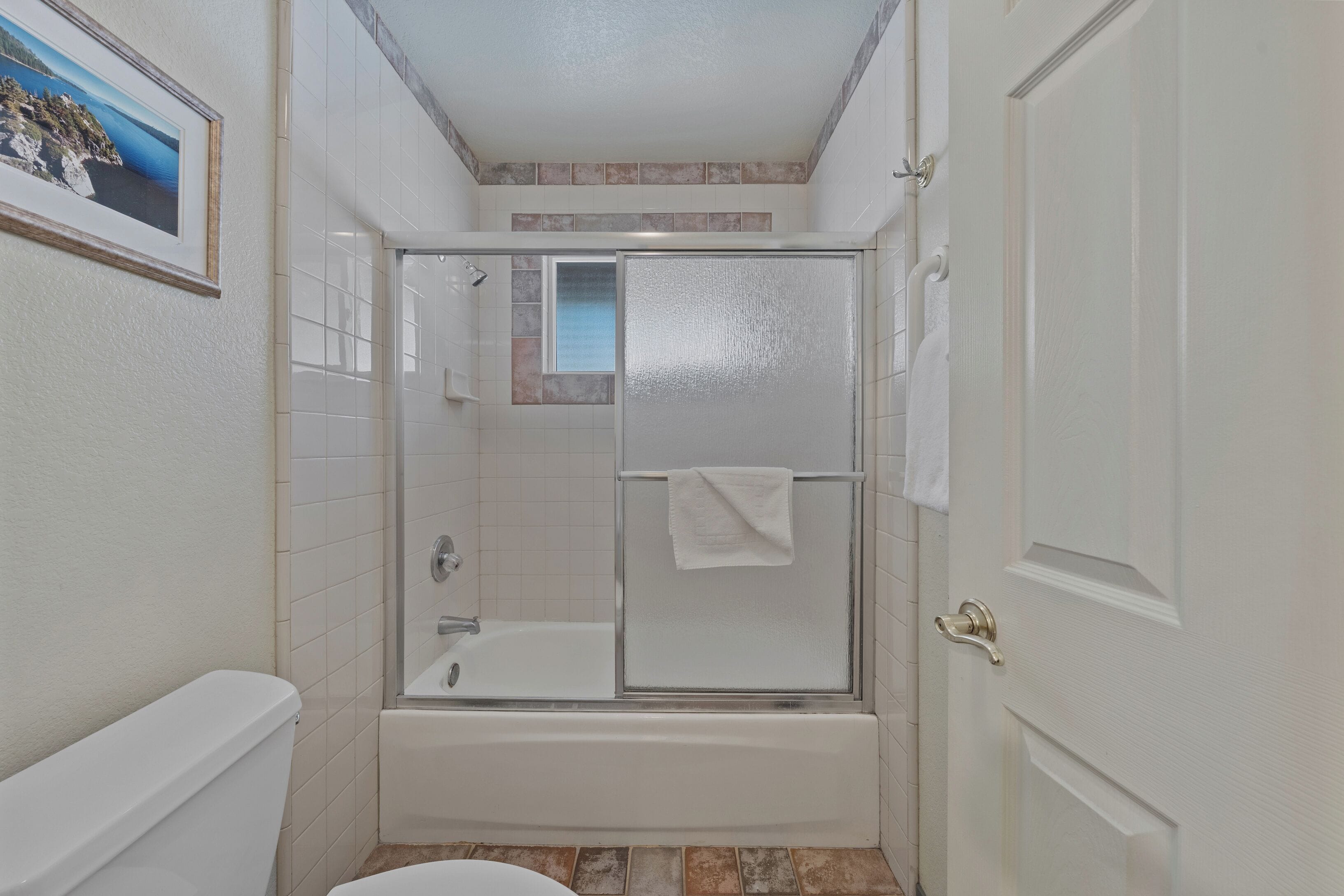 Une salle de bain avec une douche à parois de verre, une baignoire et des toilettes.