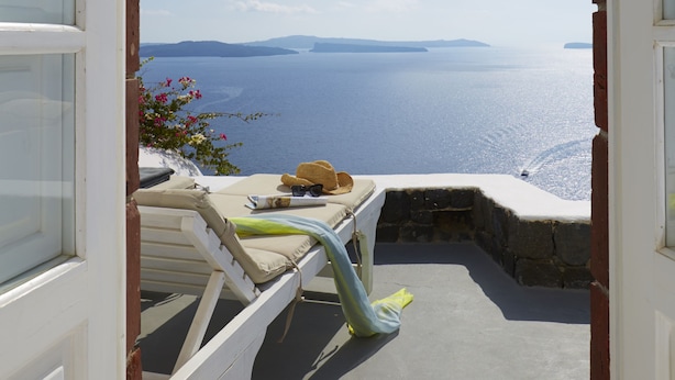 A view from a room with a white door leading to a balcony overlooking the sea. - Atrina Canava 1894 (Santorini)