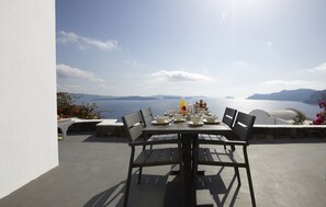 A table set for four with a view of the sea and mountains. - Atrina Canava 1894 (Santorini)