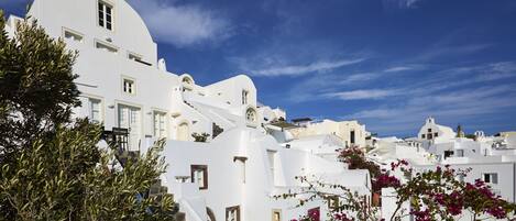 A white building with a curved roof and a staircase leading up to it.
