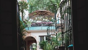 An entrance with a tiled floor leading to a covered outdoor area with plants and a staircase. - Hotel Zamna (Mérida)