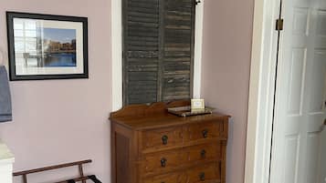Een kamer met een houten dressoir, een lijst met een foto en een deur.