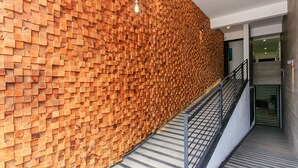 A modern interior with a wooden wall and a metal staircase. - Studio 30 Condhotel by Nah Hotels (Playa del Carmen)