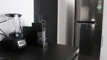 Una cocina con licuadora, cafetera y un refrigerador de acero inoxidable.