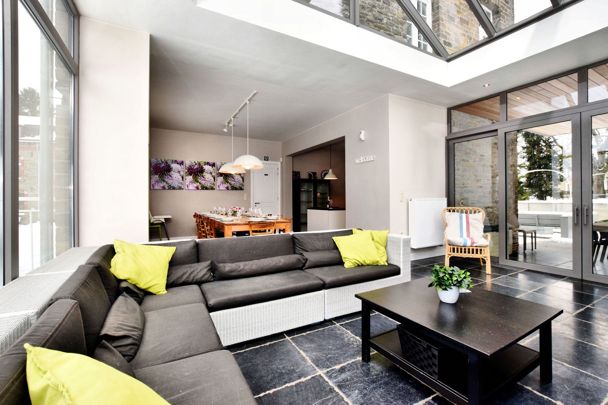 Et moderne opholdsområde med en modulsofa, et sofabord og et spiseområde i baggrunden.