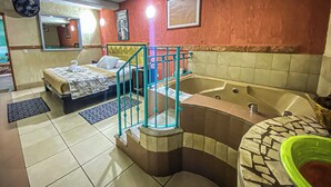 A hotel room with a bed, a bathtub, a small balcony, and a bathroom with a sink and mirror. - Azul Turquesa Hotel Boutique (Cuernavaca)