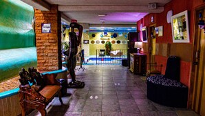 A hotel lobby with a reception desk, a bench, a staircase, and a wall with a sign. - Azul Turquesa Hotel Boutique (Cuernavaca)