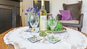 Un tavolo da pranzo con una bottiglia di vino, due bicchieri e un piatto decorativo.