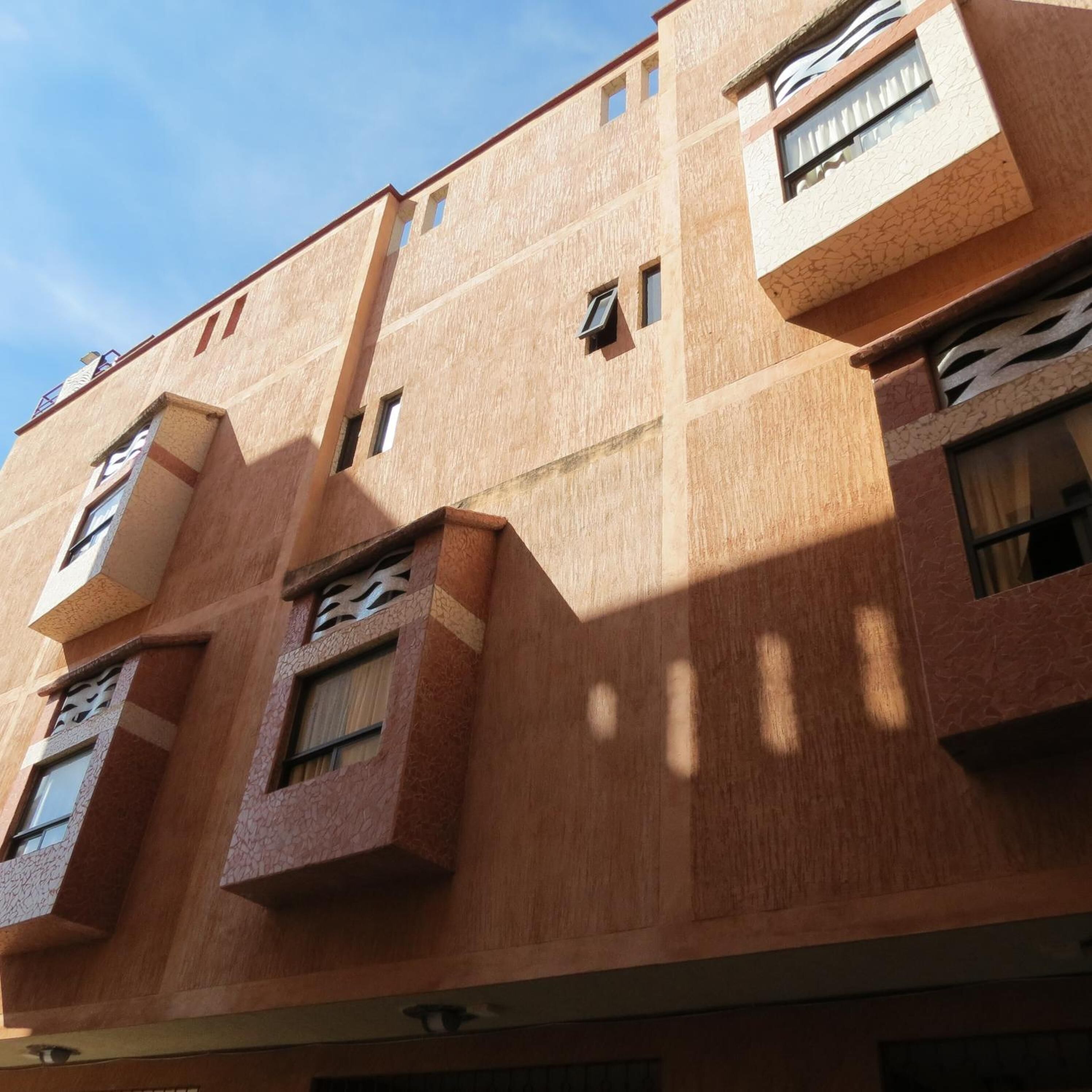 Un edificio de varios pisos con un estilo arquitectónico moderno, que cuenta con ventanas rectangulares y balcones.