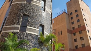 Um edifício alto com fachada em mosaico único e várias janelas.
