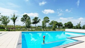 A rectangular swimming pool with a clear blue water surface, surrounded by a tiled deck area. - Drenthe Family Getaway w/ Garden (West-Graftdijk)