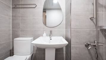 Un baño moderno con inodoro, lavabo y ducha.