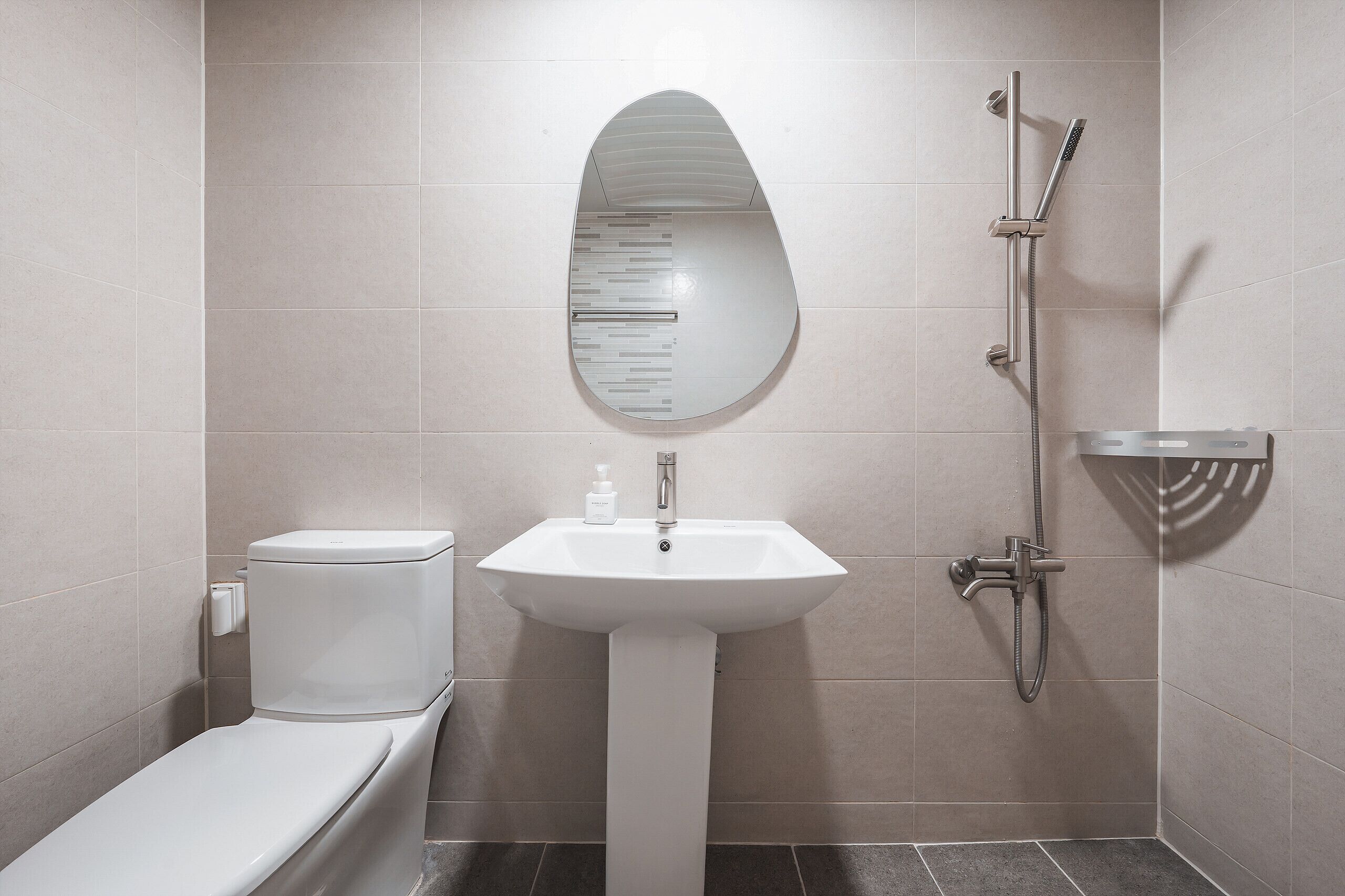 A modern bathroom with a toilet, sink, and shower.
