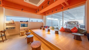 A modern interior with a reception desk, seating area, and a view of the outside.