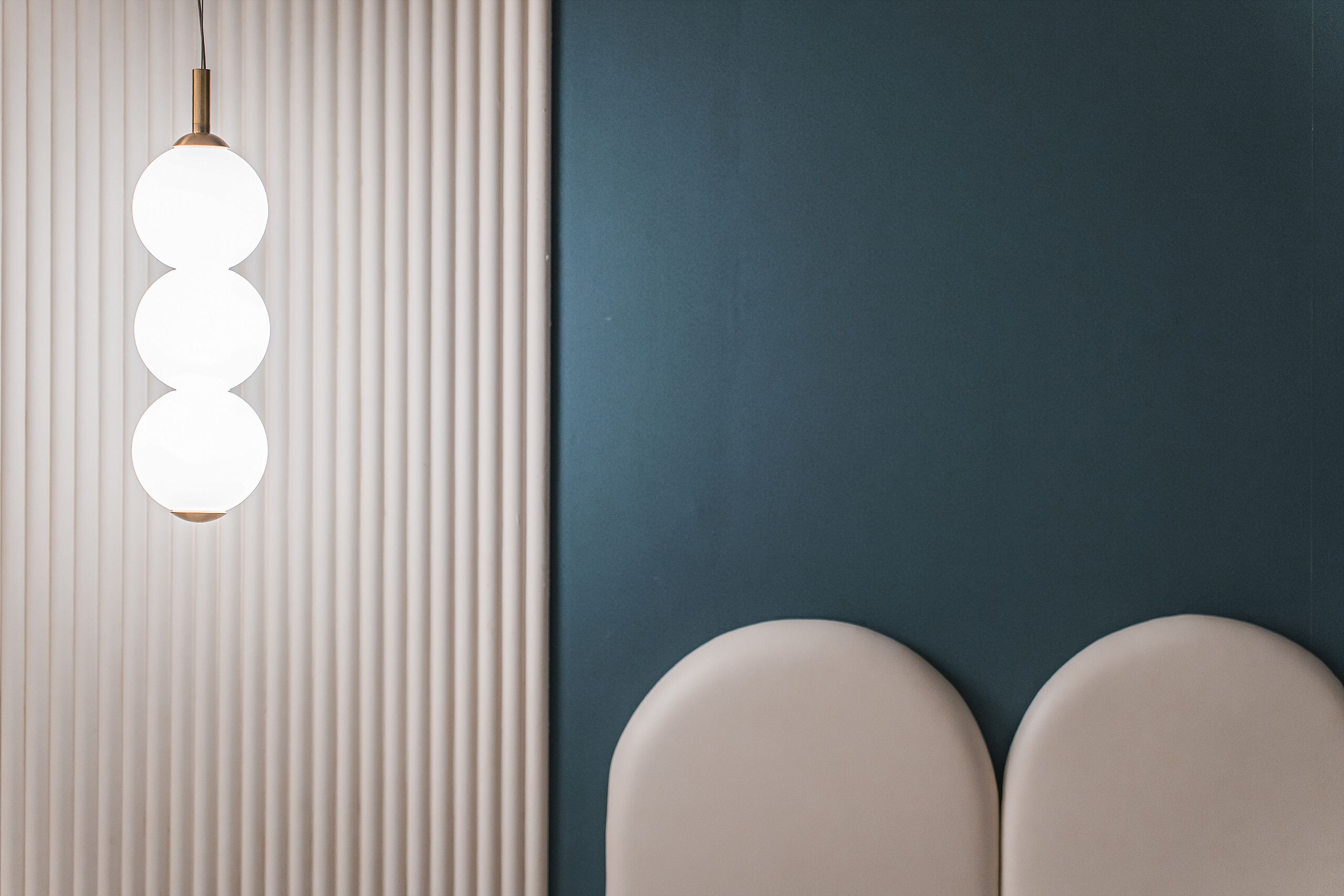 A modern bathroom with a vertical light fixture and two round white sinks.