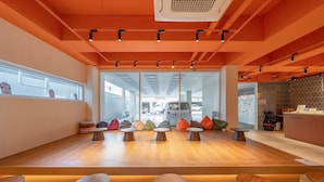 A modern interior with a wooden reception desk, seating area, and large windows.