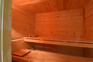 Un cuarto de sauna con paredes y bancos de madera.