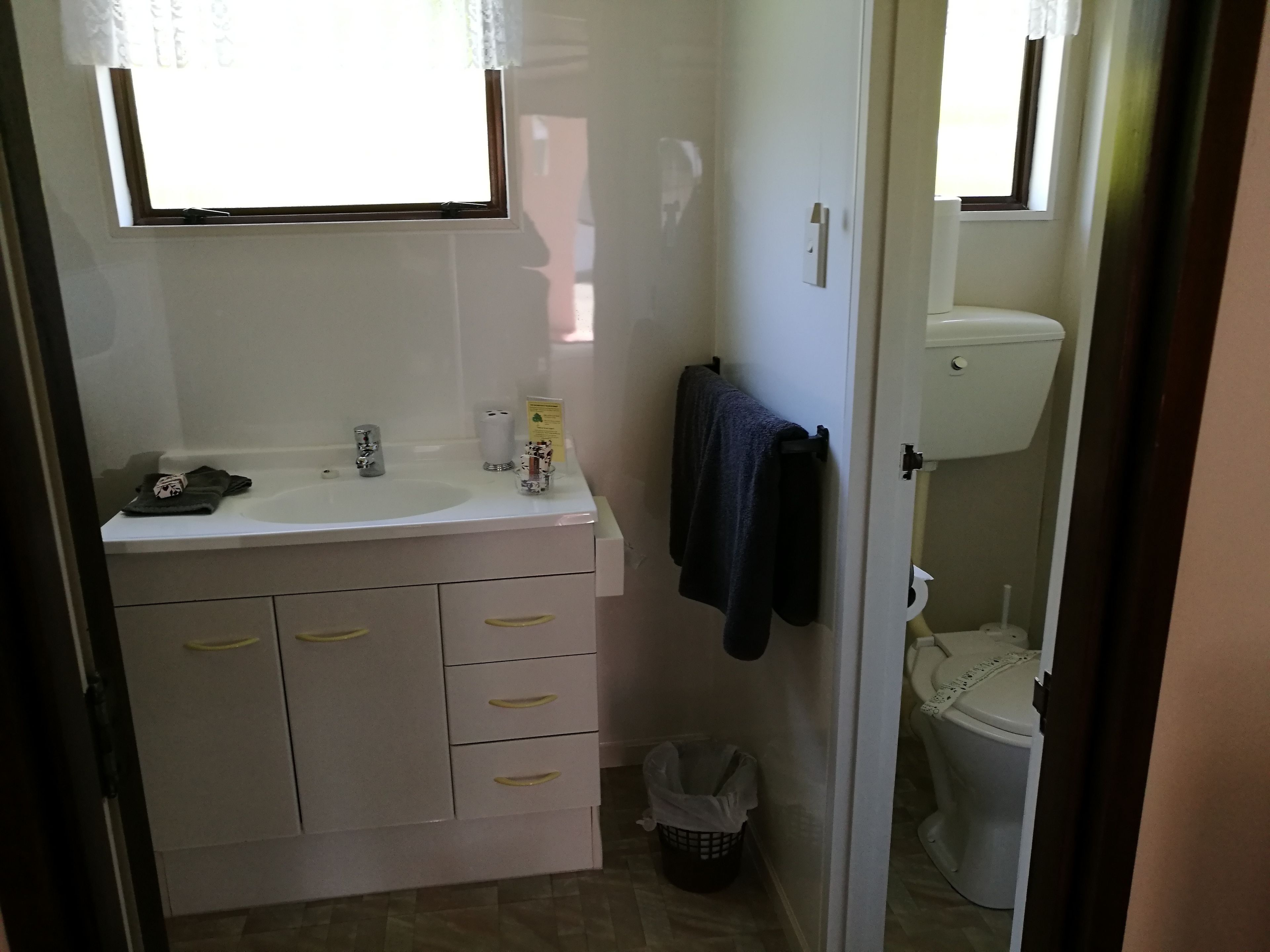 A bathroom with a sink, mirror, towel rack, and toilet.