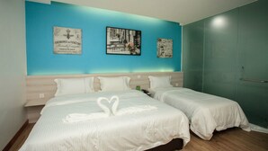 A hotel room with two beds, a blue accent wall, and three framed pictures. - A Plus Boutique Hotel (Sekinchan)