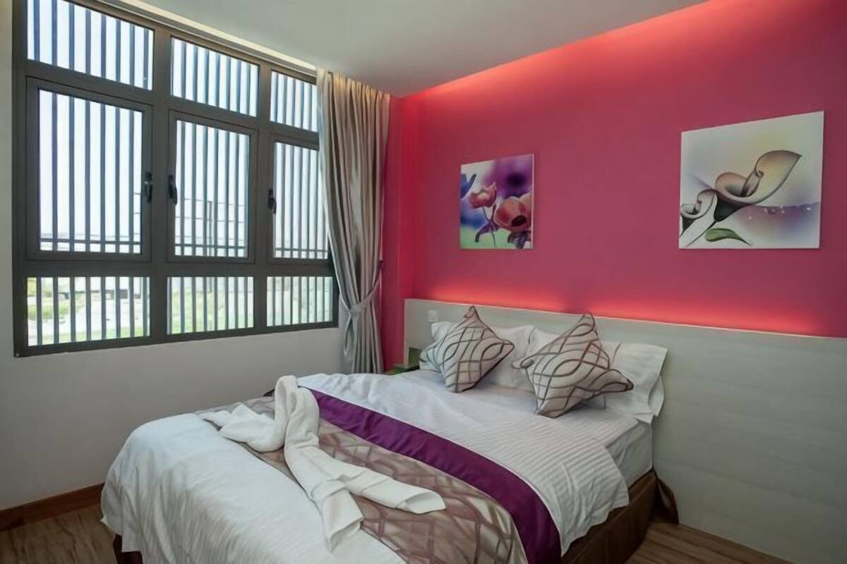Un dormitorio con una cama, un ventanal con persianas y dos obras de arte colgadas en la pared.