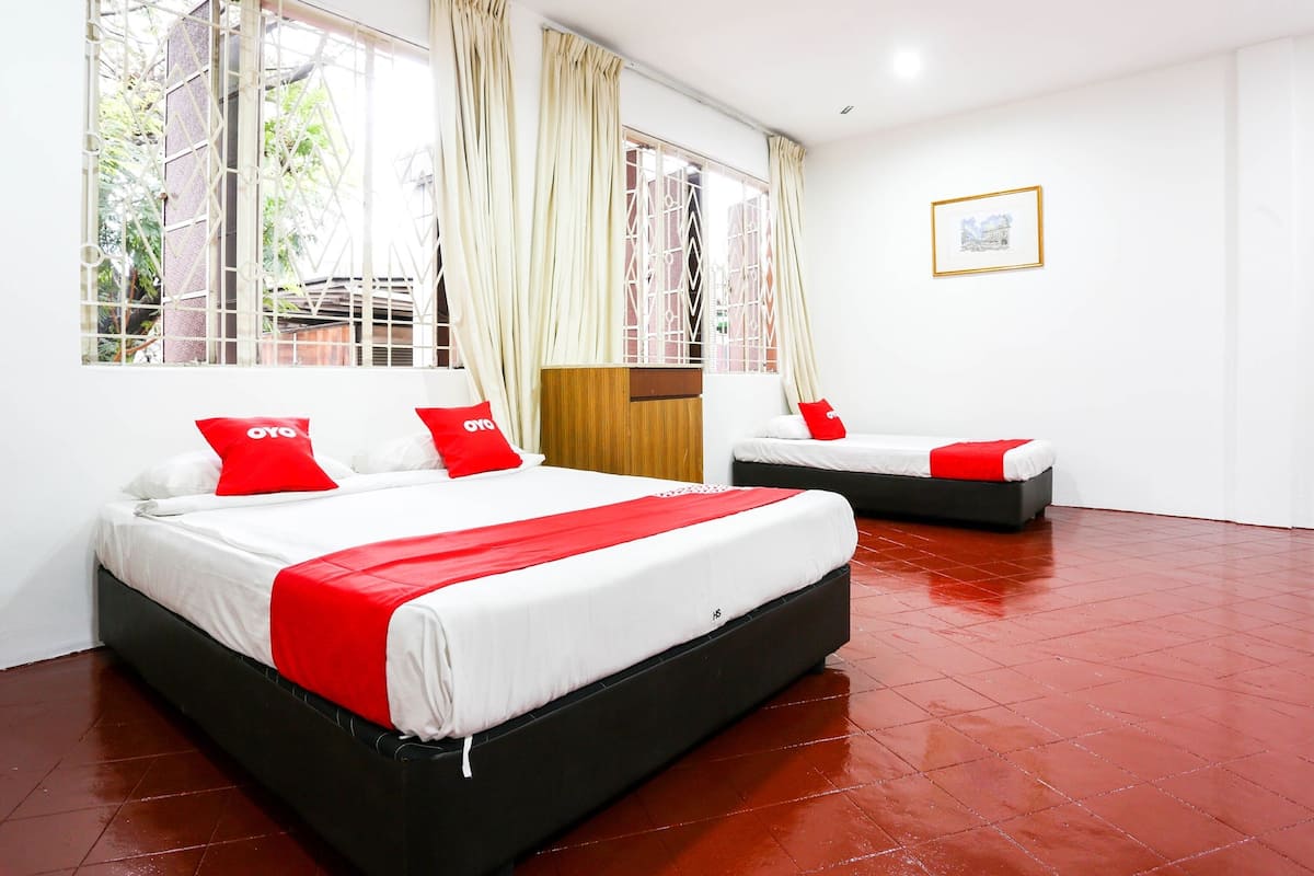 Habitación de hotel con dos camas, cabecero de madera, ventana grande con cortinas e imagen enmarcada en la pared.