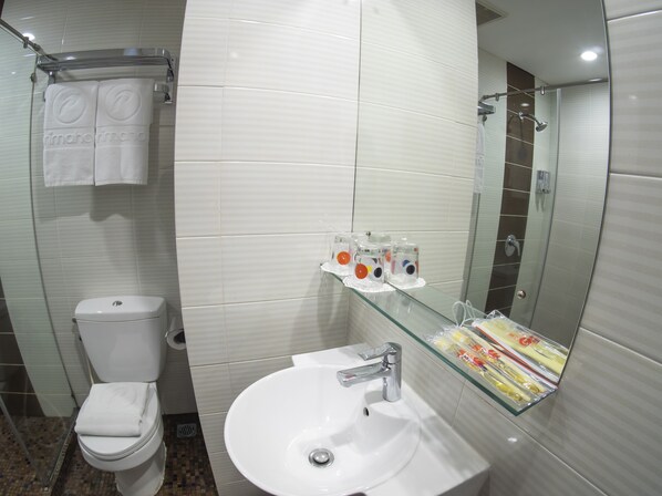 A bathroom with a toilet, sink, and shower.