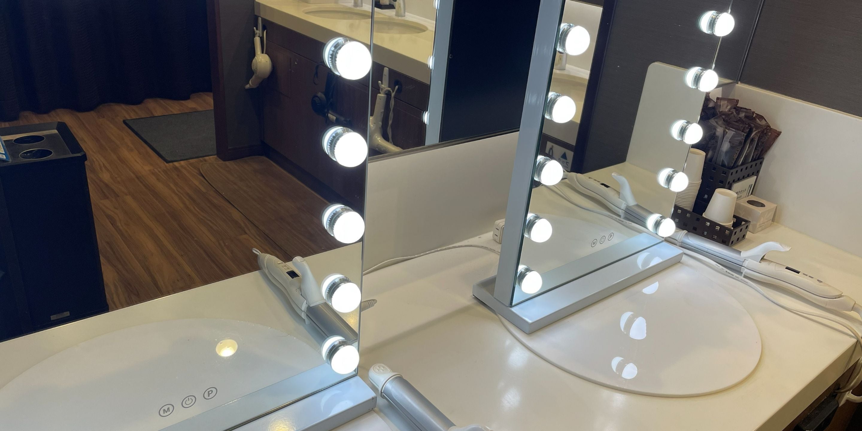 Un tocador de baño con espejo, luces y un secador de pelo.