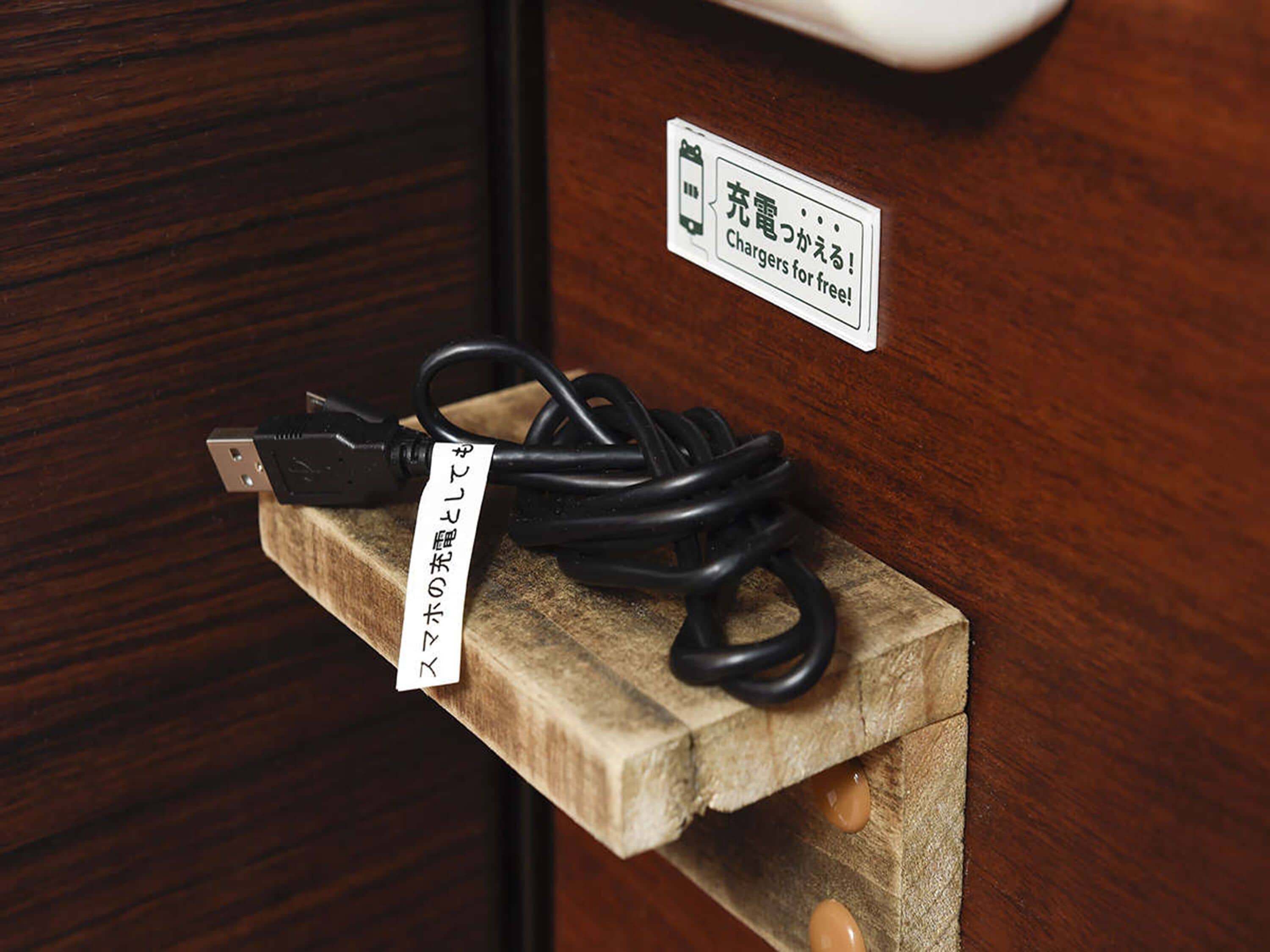 A wooden charging station with a sign indicating free chargers.