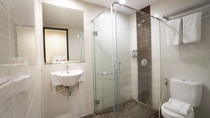 Une salle de bain moderne avec une douche à parois de verre, un lavabo et des toilettes.