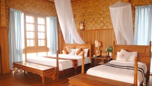 A room with two wooden beds, a wooden bench, and a woven wall. - Golden Island Cottages Nampan Hotel (Nyaungshwe)