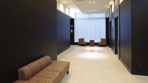 Un hall d’entrée moderne avec un canapé à motifs, une petite table et des chaises.