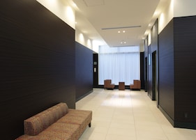 A modern lobby with a patterned sofa, a small table, and chairs.