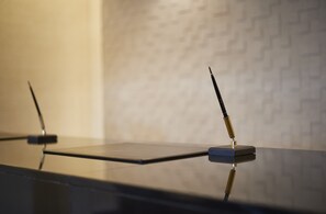 A modern, minimalist table with a reflective surface and two pens standing upright. - JR East Hotel Mets Yokohama Tsurumi (Yokohama)