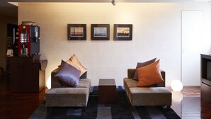 A living room with two sofas, a coffee machine, and three framed pictures on the wall. - JR East Hotel Mets Yokohama Tsurumi (Yokohama)