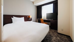 A hotel room with a large bed, a desk, a chair, a television, and a window with curtains. - JR East Hotel Mets Yokohama Tsurumi (Yokohama)