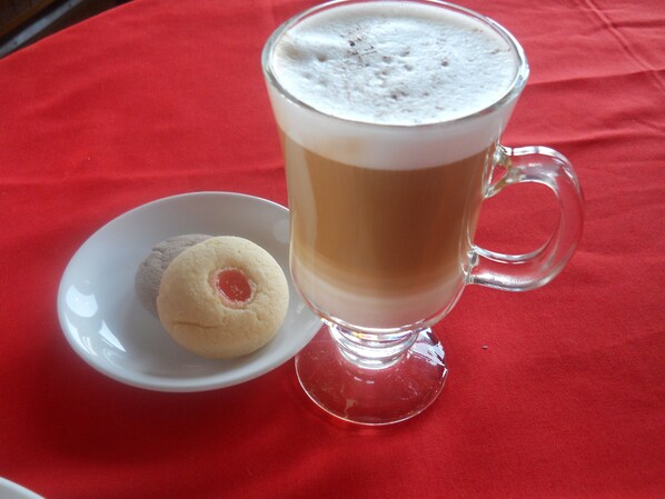 A clear glass mug with a foamy top, placed on a red tablecloth. - Golden Island Cottages Thale-U Hotel (Nyaungshwe)