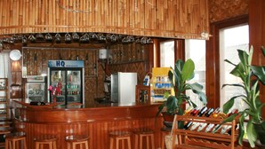A bar area with wooden decor, a refrigerator, and a wine rack. - Golden Island Cottages Thale-U Hotel (Nyaungshwe)