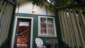 A wooden staircase leading to a green door with a window above it.