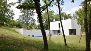 A modern white building with a flat roof, surrounded by trees and grass. - Holiday Home in Boissières with Private Pool (Boissieres)