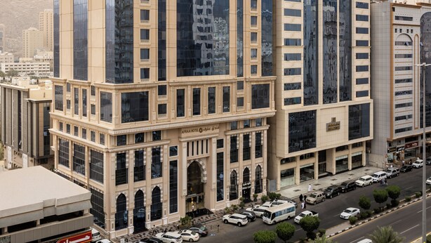 A high-rise building with a modern glass facade and classical architectural elements. - Afraa Hotel (Makkah)