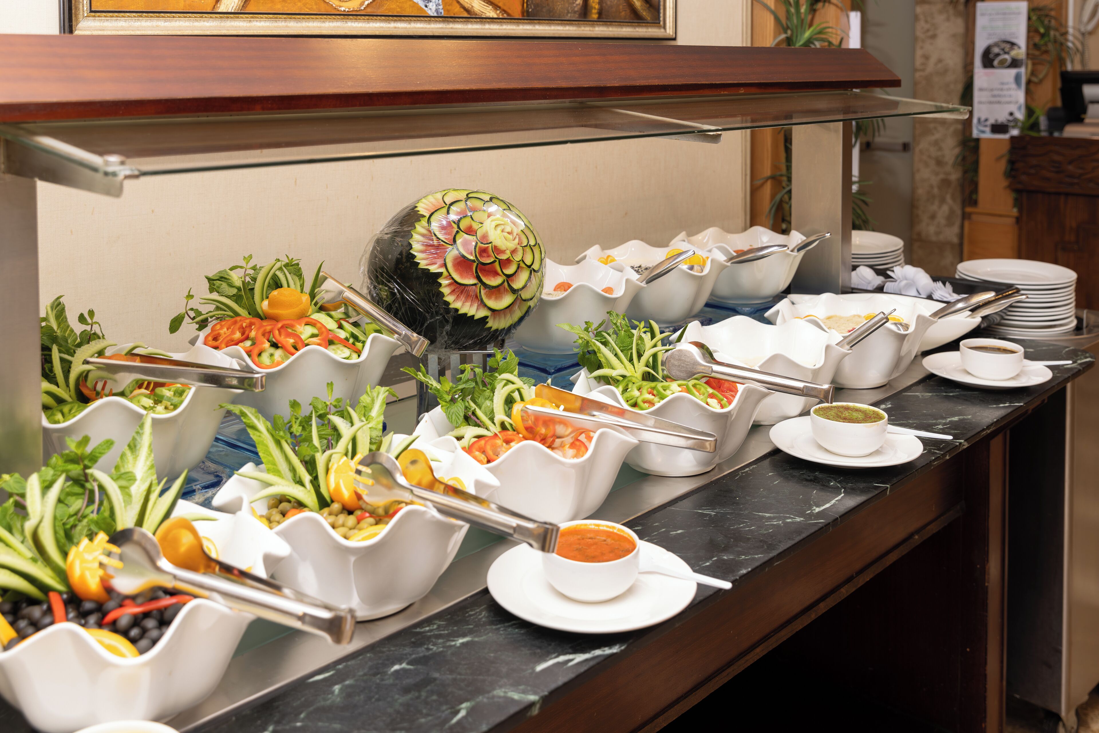 A buffet with various food items and utensils.