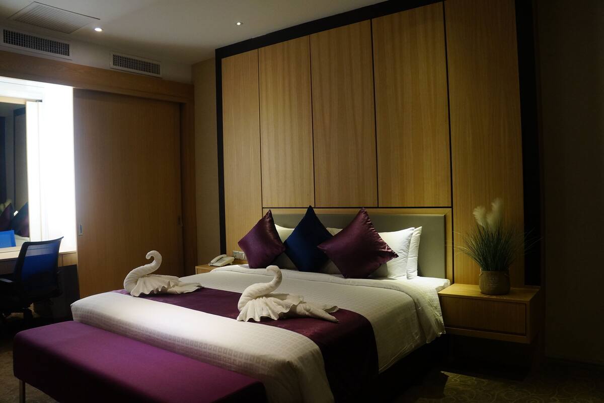 A hotel room with two beds, a desk, and a chair.