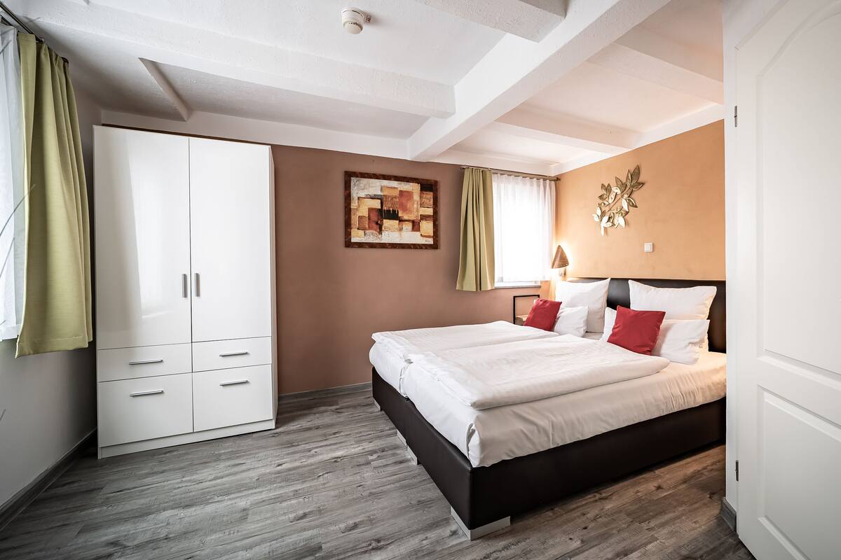 Une chambre à coucher avec un lit, une armoire et un tableau accroché au mur.