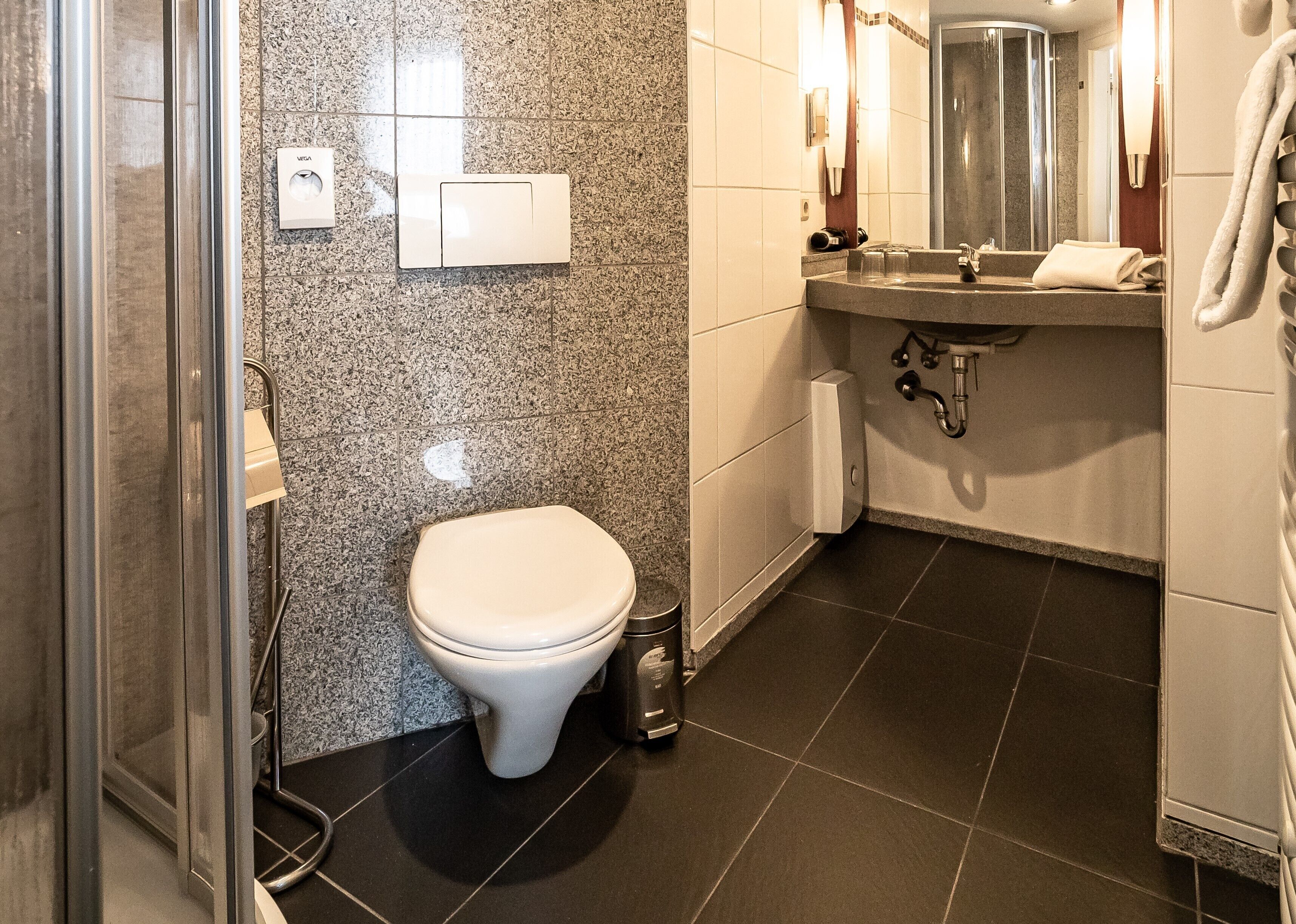 Un baño con inodoro, lavamanos y ducha.