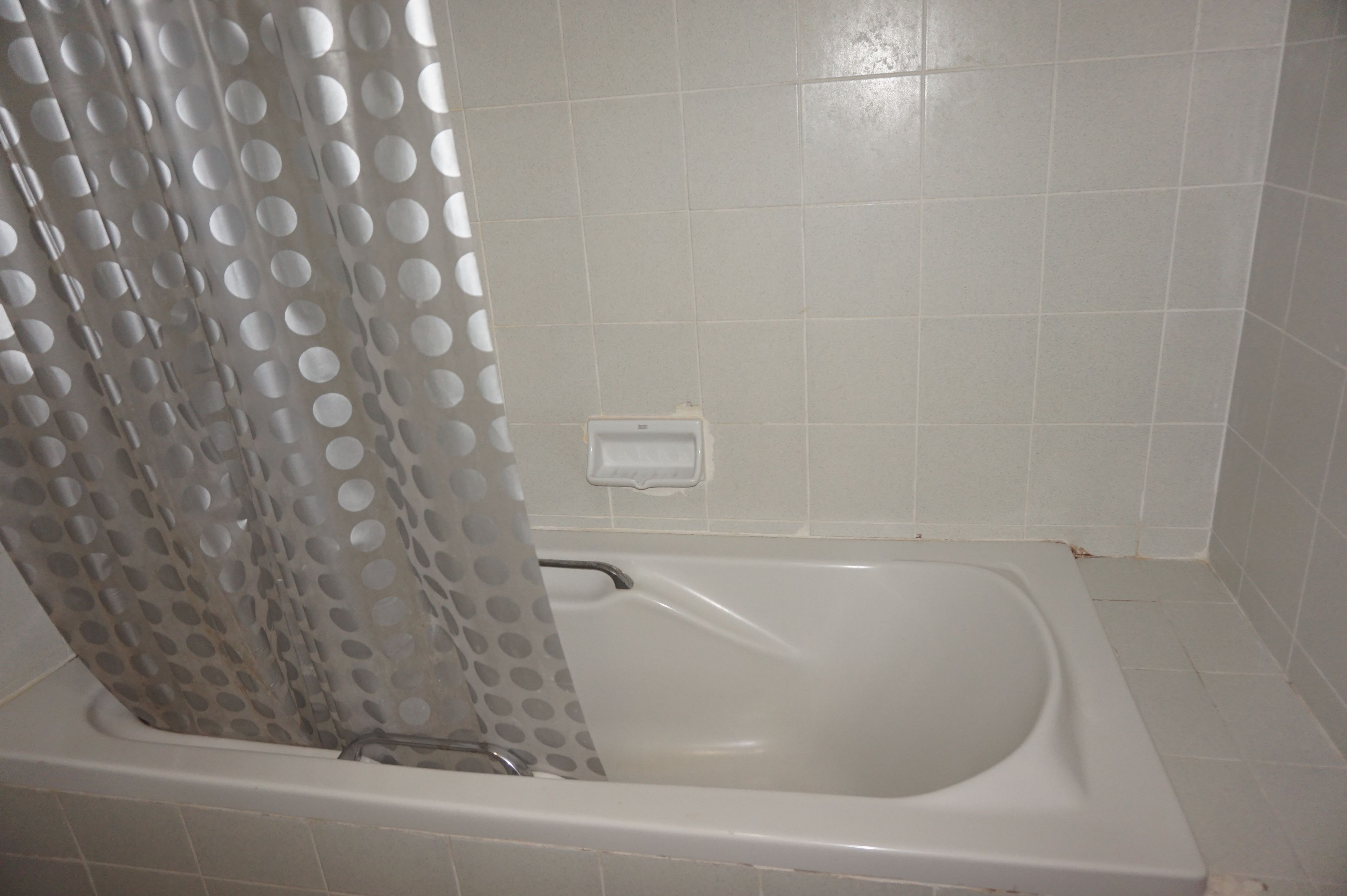 Una bañera con cortina de ducha.