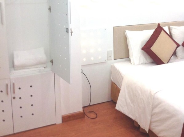 A bedroom with a bed, a wardrobe, and a bathroom door.
