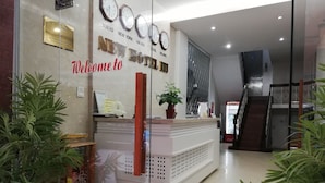 A reception desk with a glass partition, clocks displaying multiple time zones, and a welcome sign.