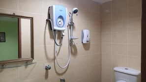 A bathroom with a shower, a toilet, and a hand dryer.