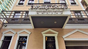 El hotel Windy Ridge, con un diseño arquitectónico clásico, presenta una entrada destacada y un balcón con barandillas.