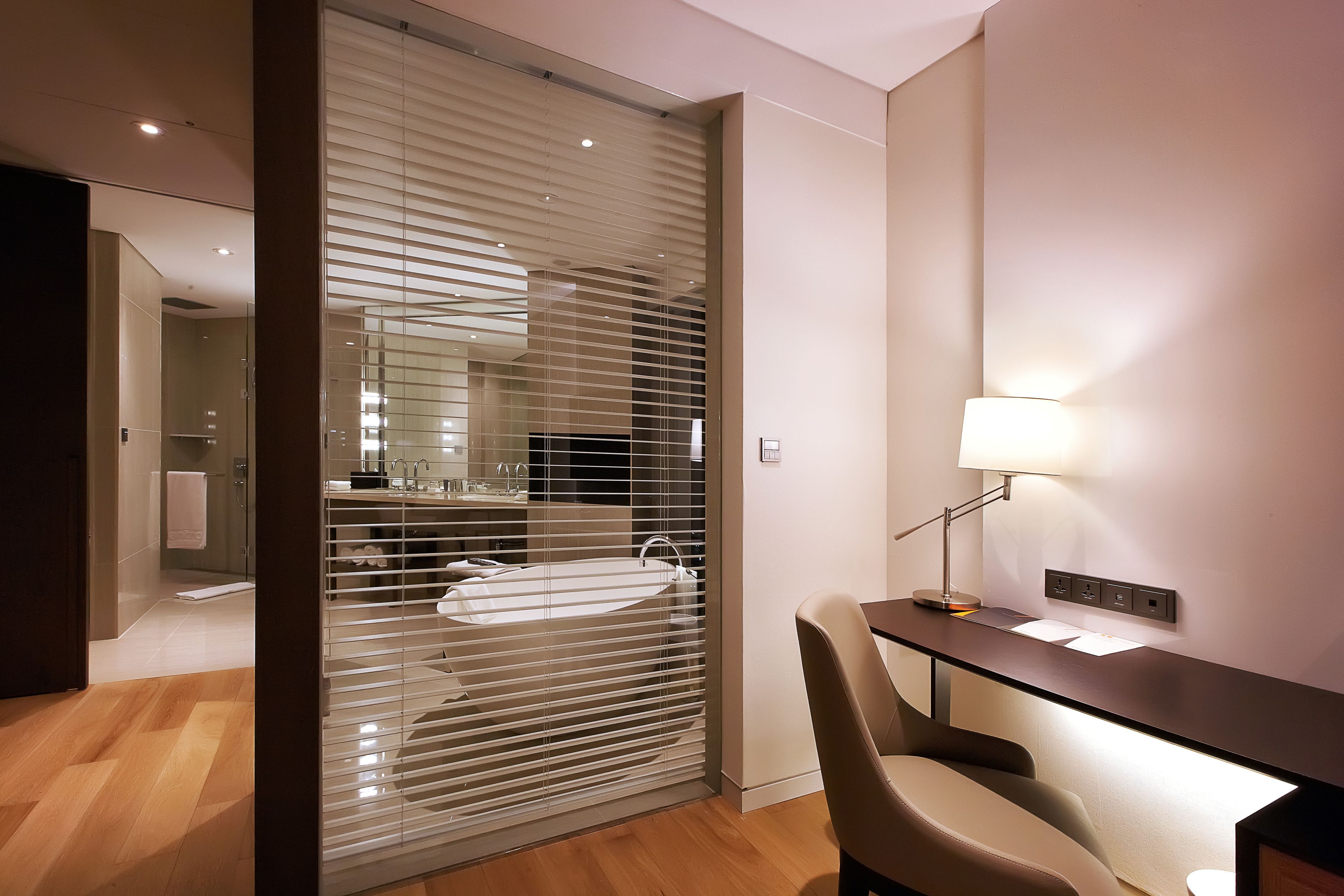 Un baño moderno con separador de vidrio, un lavamanos y un espejo.